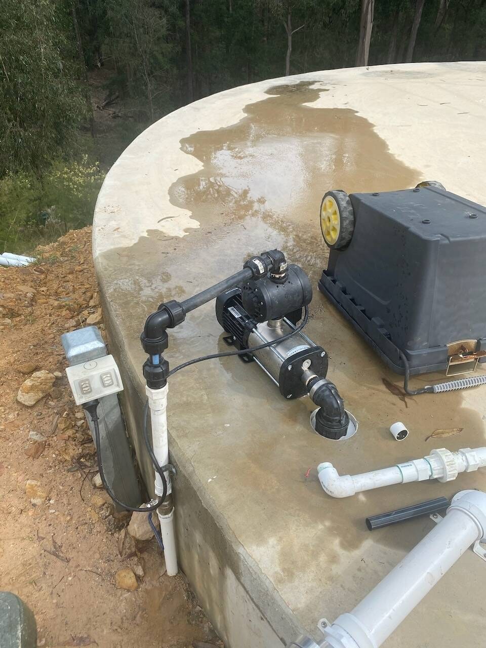 Pump and controller fitted on a concrete water tank
